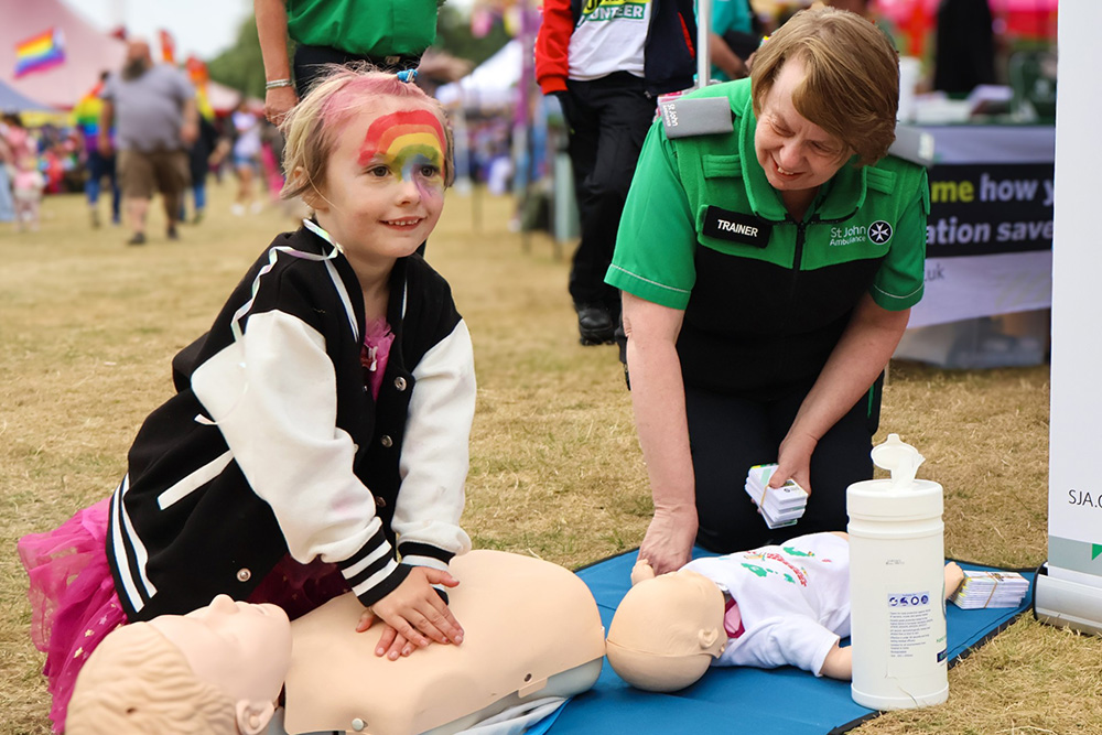 A young girl learning the basics of CPR.