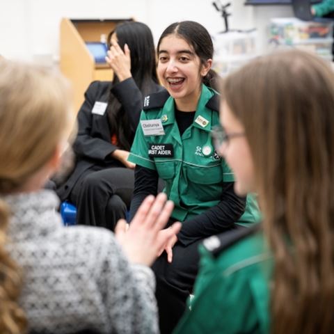 A cadet first aider smiling in a group of young people.